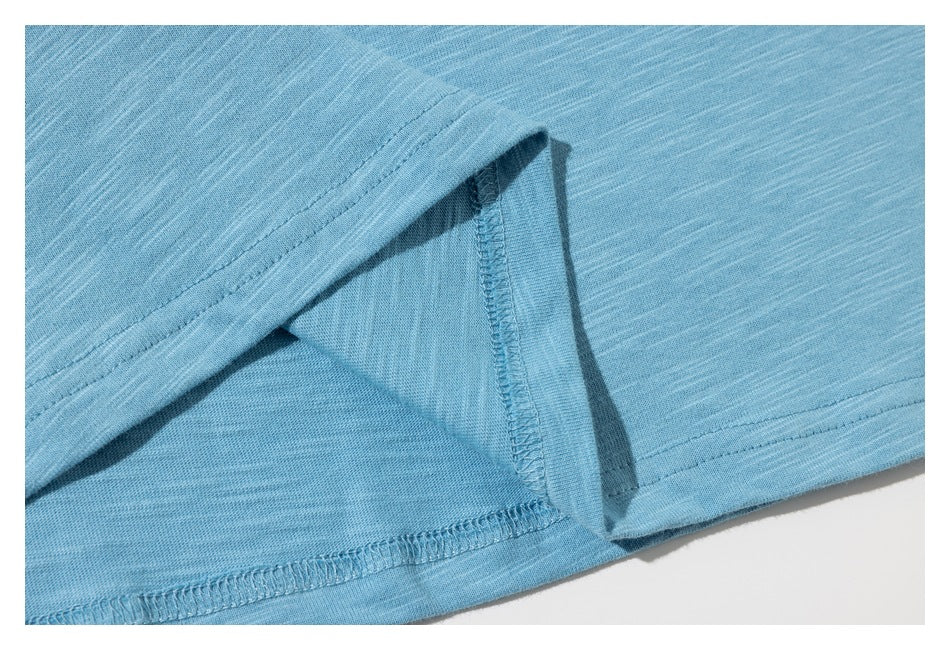Close-up of the light blue shirt’s bottom hem, showing the stitching and inside seam.