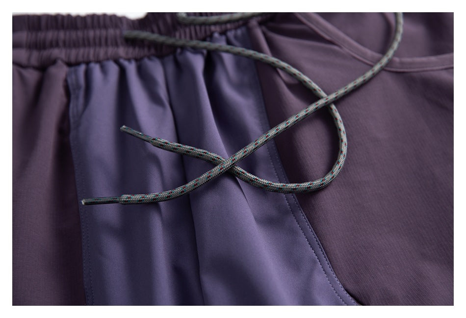 Close-up of purple shorts with an elastic waistband and multicolored drawcord.