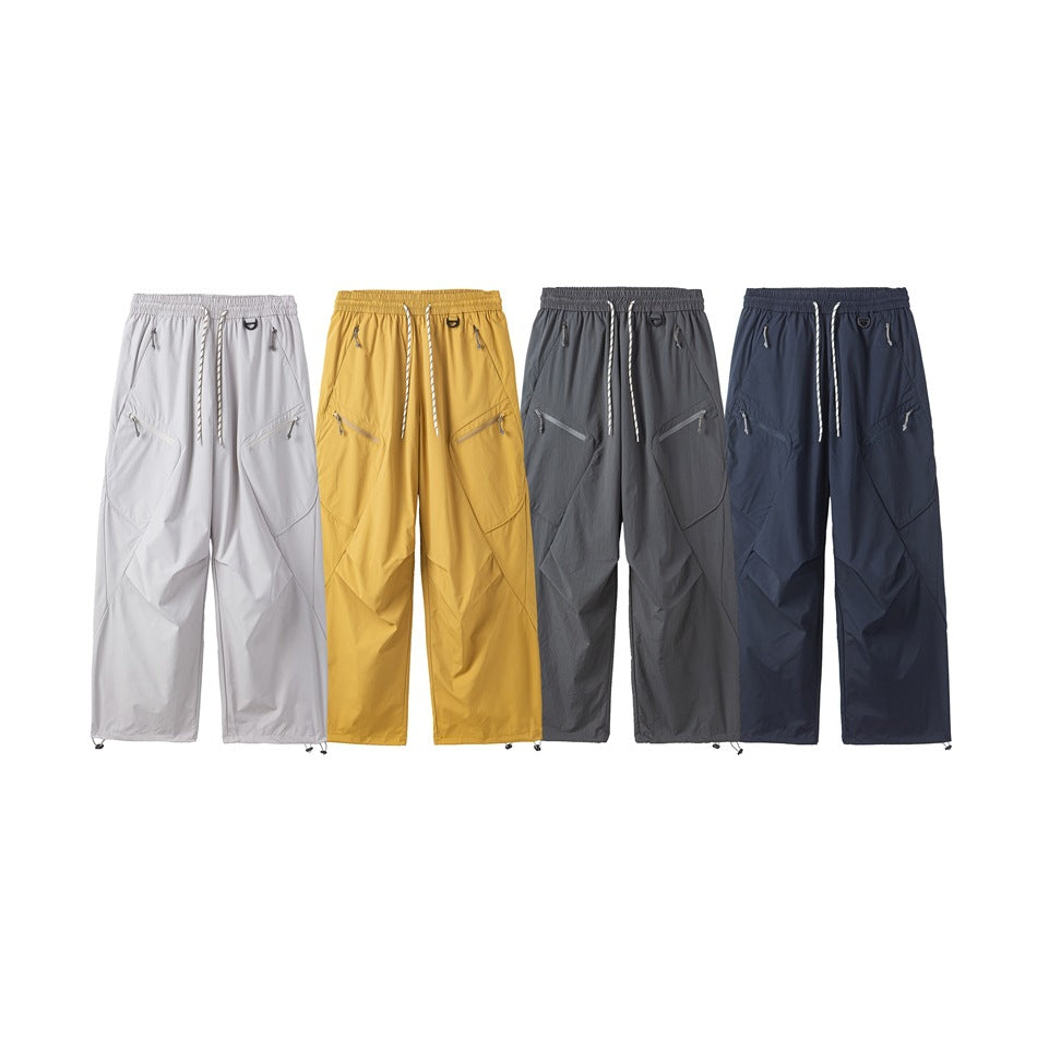 Four pairs of wide-leg drawstring trousers shown from the front in white, mustard, gray, and navy.