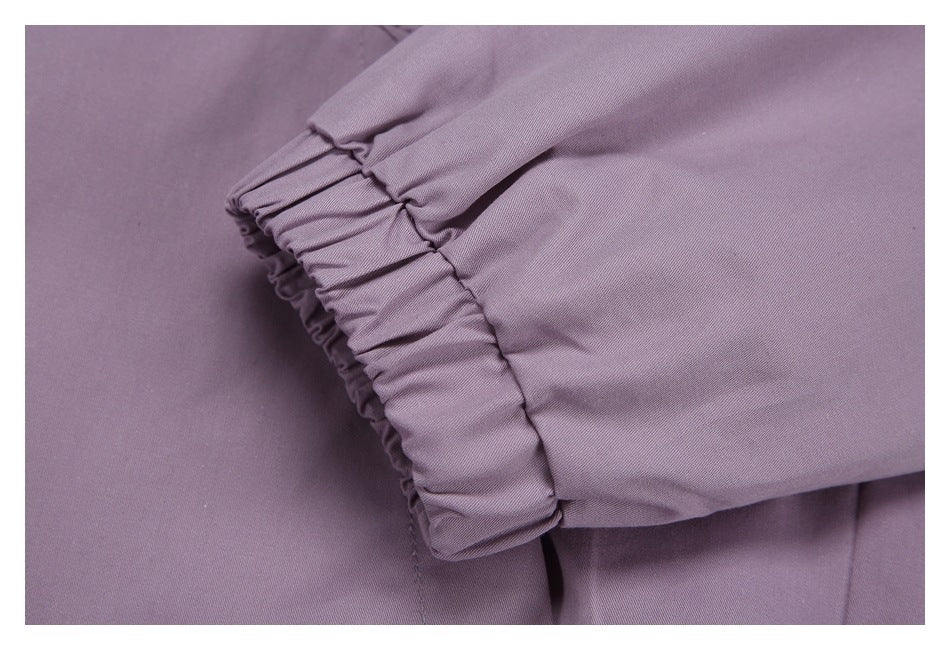 Close-up of a gathered cuff on a muted lavender garment.