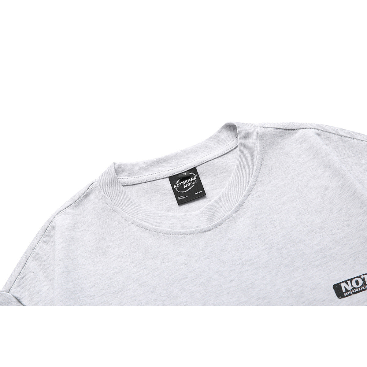 Close-up of a light gray heather T-shirt neckline, neck label, and small black chest logo.