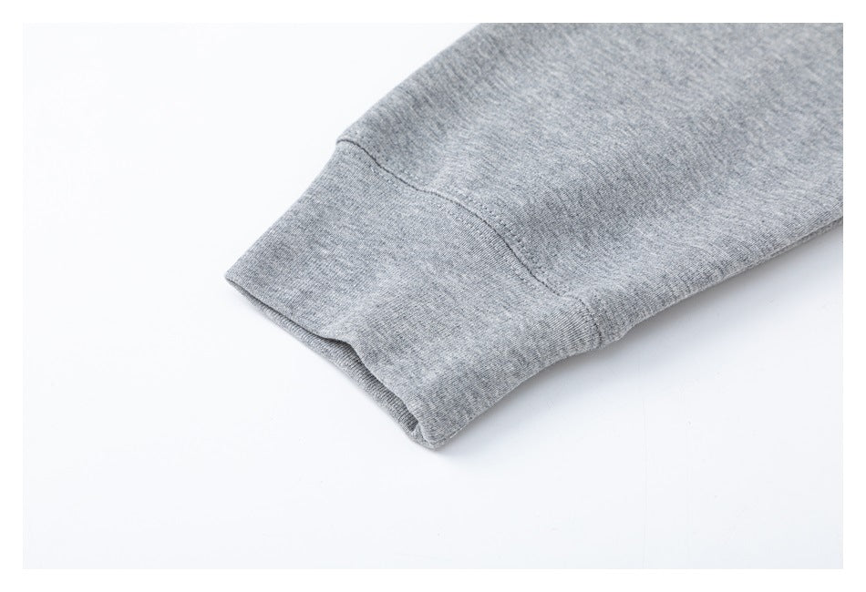 Close-up of a ribbed cuff and seam on heather gray knit fabric.