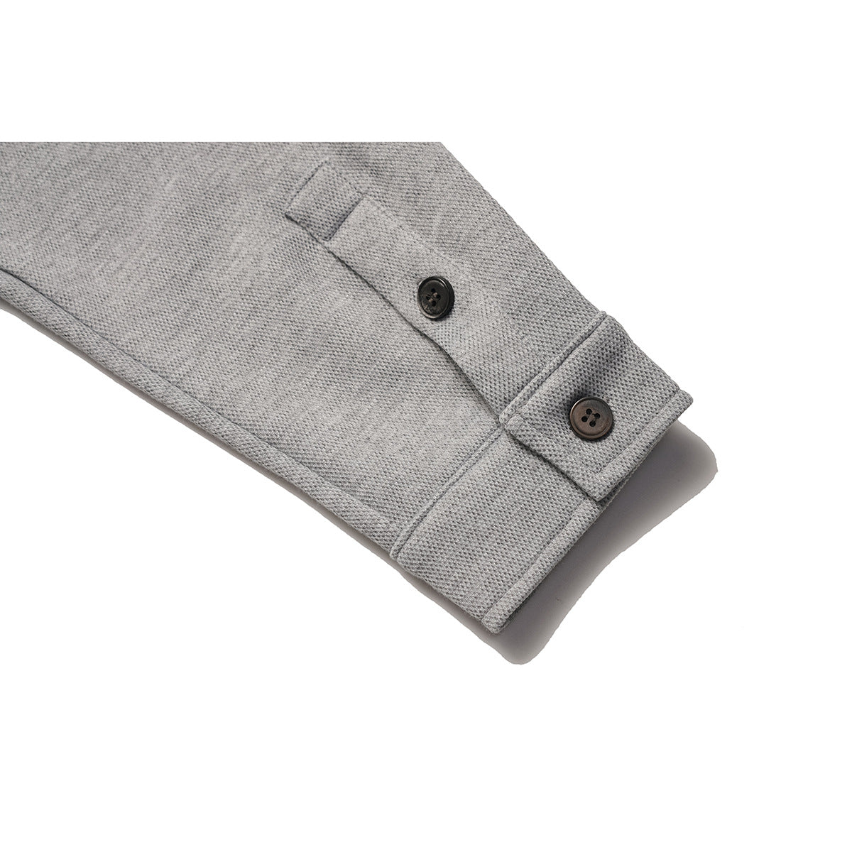 Close-up of a heather gray sweatshirt sleeve cuff with two dark buttons and a buttoned tab.