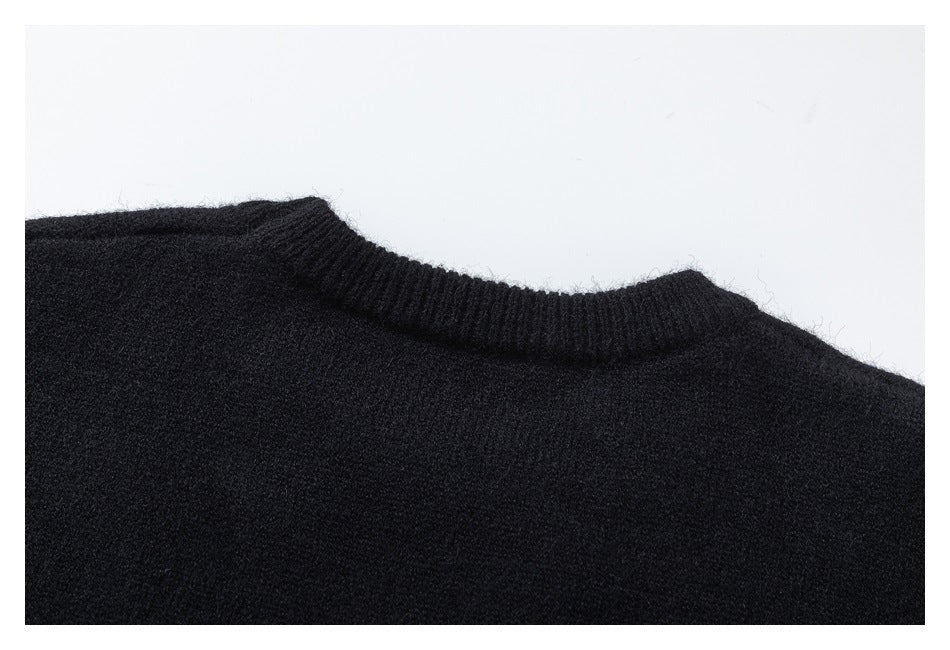 Close-up of the ribbed crew neckline and upper body of a black knit sweater.