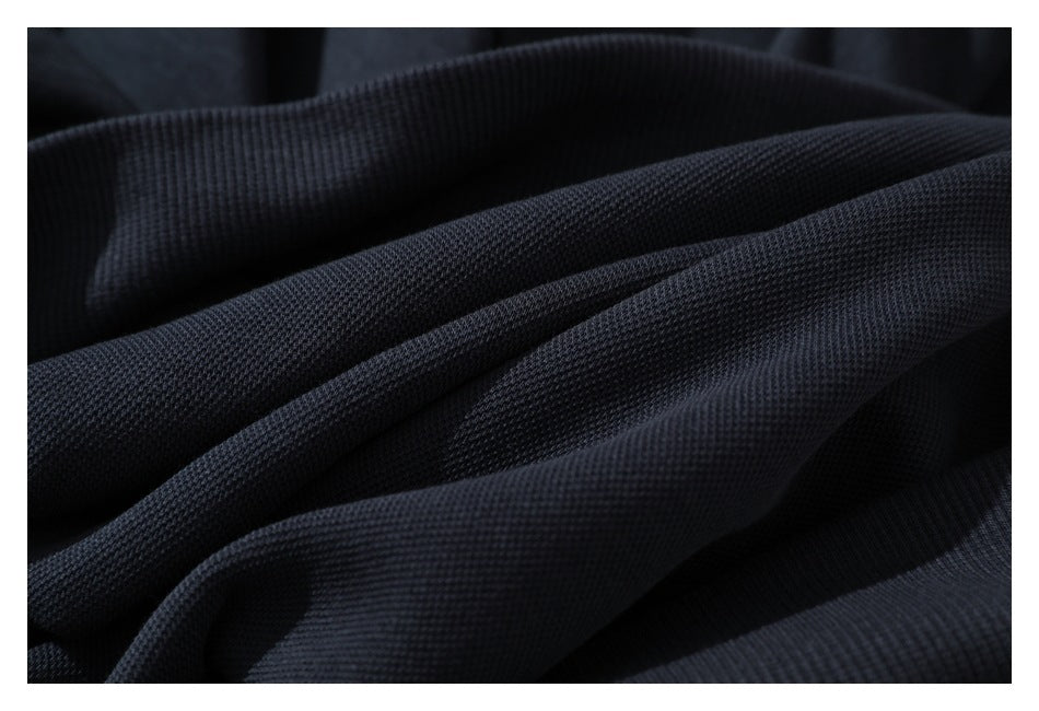 Macro view of the dark navy pullover fabric and ribbed trim in layered folds.