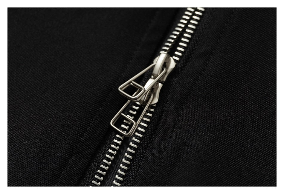 Close-up of a silver double-pull zipper on black fabric.