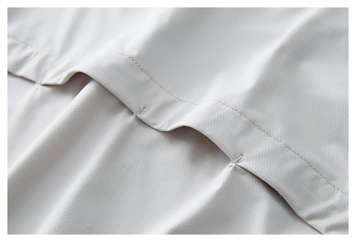 Close-up of white textured fabric showing a curved stitched seam.