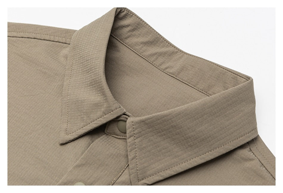 Close-up of a taupe shirt collar, neckline, and matching button.