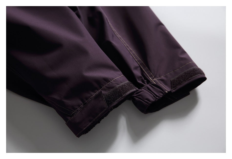 Close-up of dark plum garment cuffs with hook-and-loop tabs and an elasticized section.