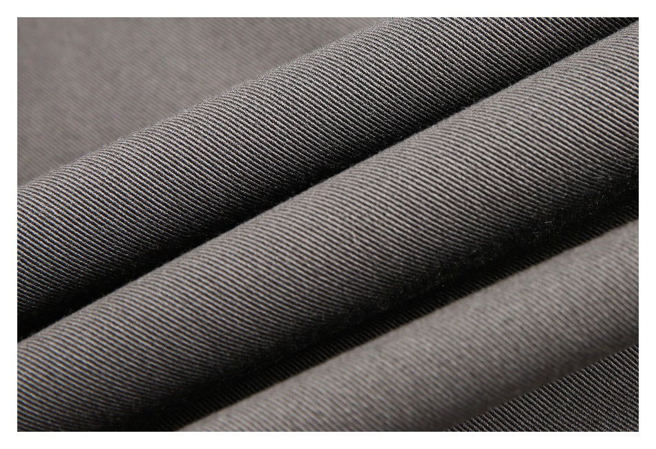 Macro view of the fine diagonal weave and texture of gray trouser fabric.