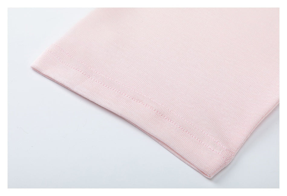 Close-up of pale pink garment fabric showing a neatly stitched folded hem.