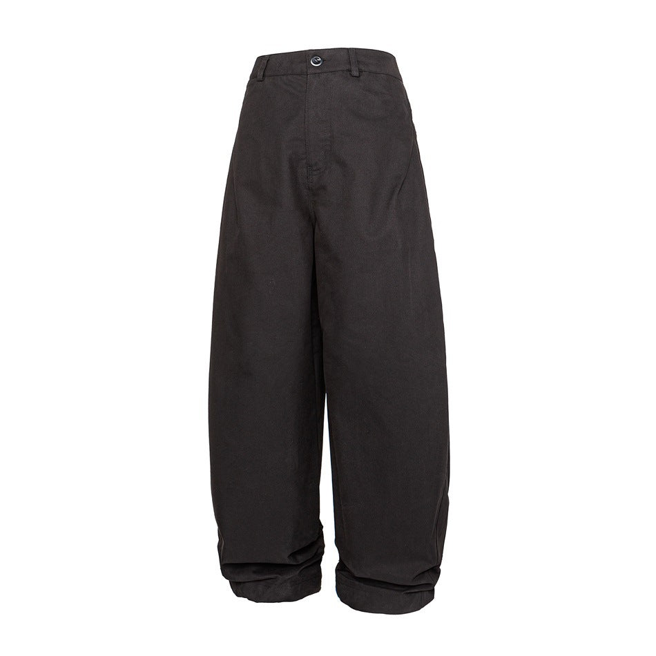 Black wide-leg curved trousers with button waistband and gathered hems, front view on white background