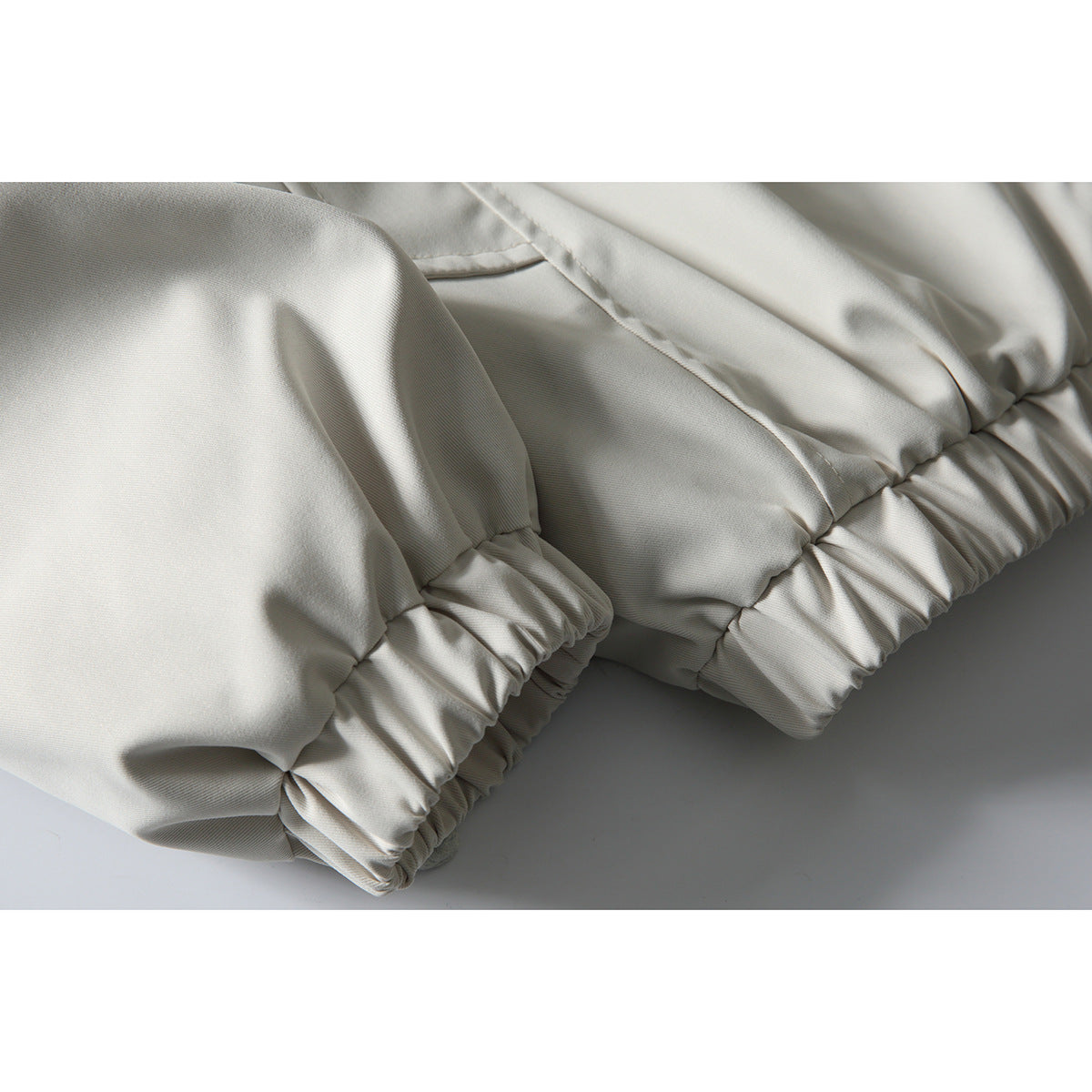 Close-up of the off-white jacket’s gathered elastic cuffs and hem.