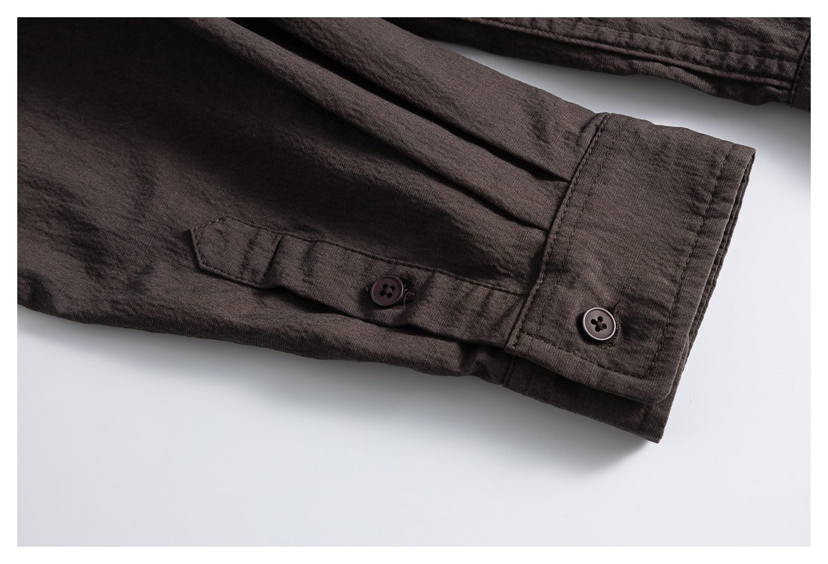 Close-up of a dark brown shirt cuff with a buttoned sleeve tab.