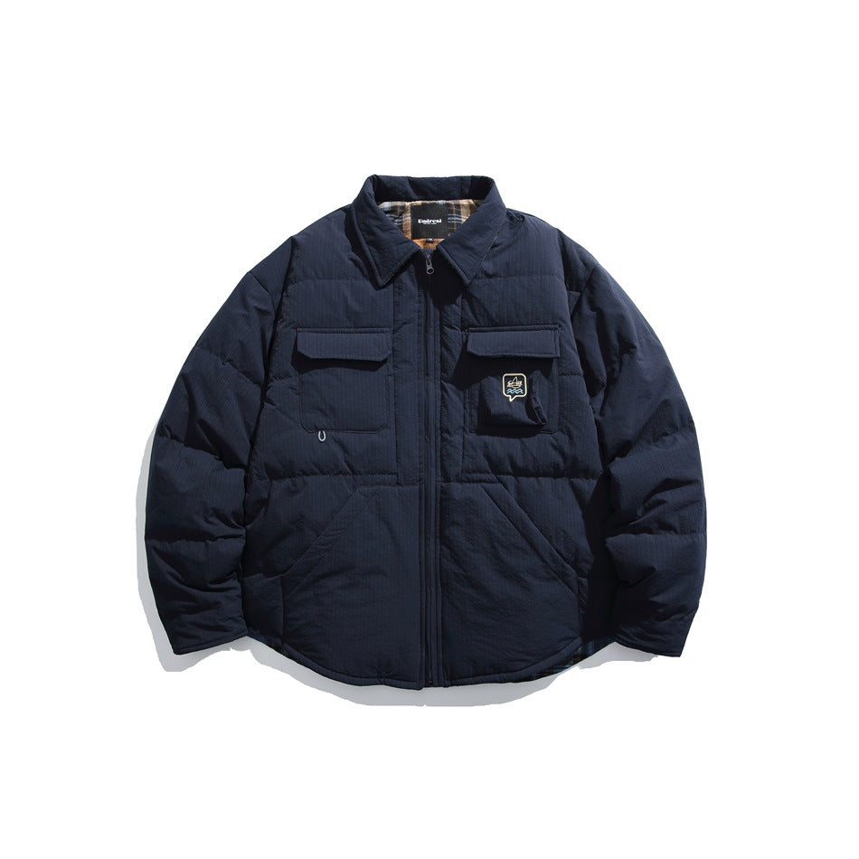Navy blue quilted shirt-style jacket with front zipper, flap chest pockets and plaid lining at the collar