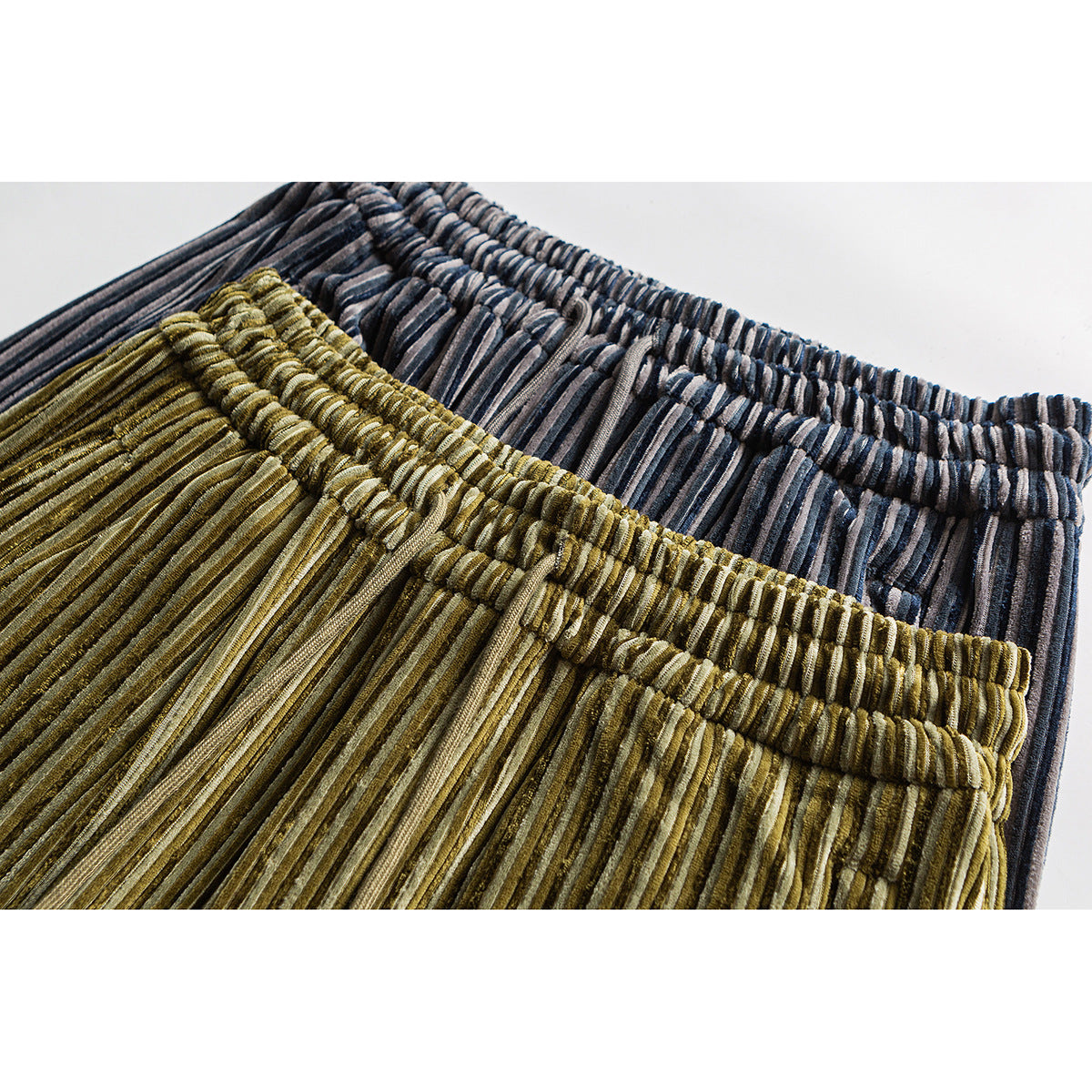 Close-up of elastic waistbands on olive and charcoal striped pants.