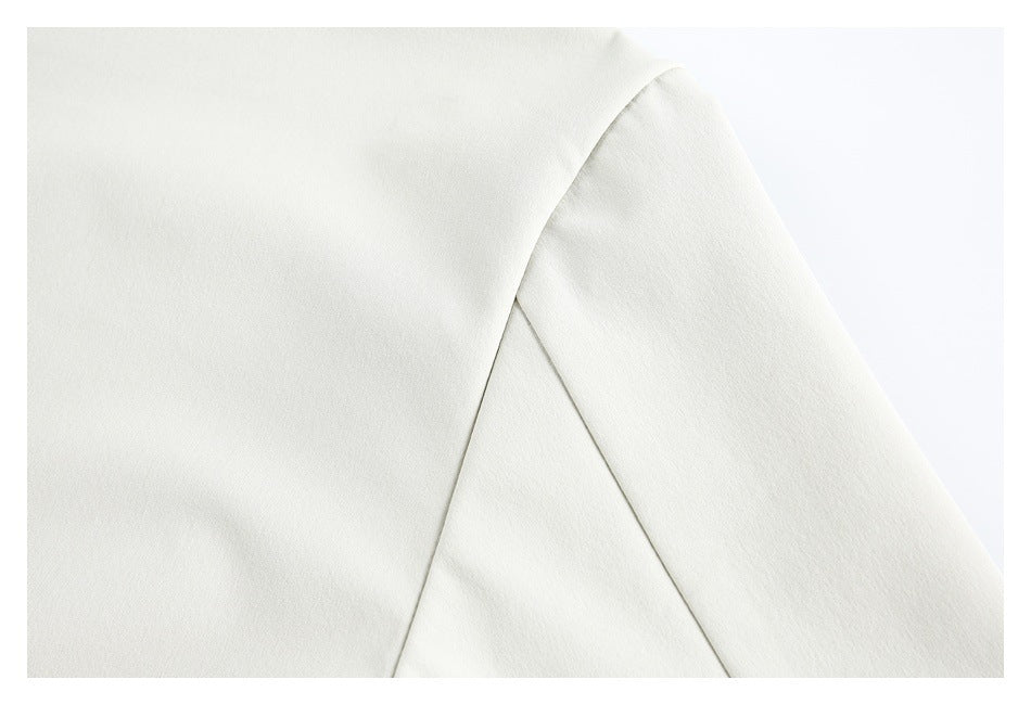 Close-up of a white garment showing a curved seam where the sleeve joins the body.