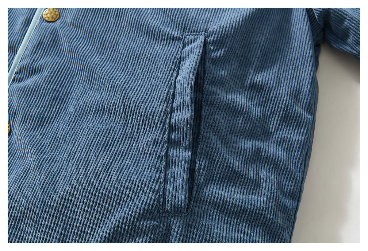 Close-up of the blue ribbed jacket's vertical side pocket and brass-colored front snap.