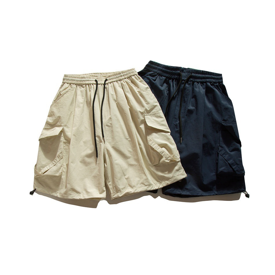 Cream and navy cargo shorts shown together from the front, with elastic waists and black drawstrings.