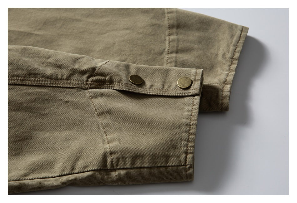 Close-up of an olive-khaki sleeve cuff with a snap-tab closure and two metal snaps.