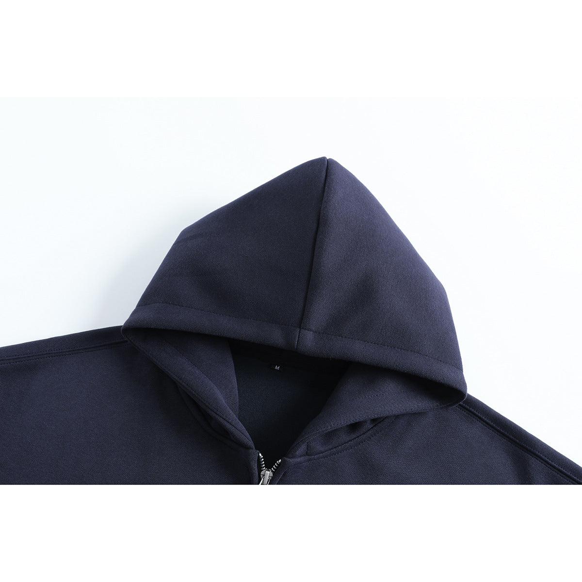 Close-up of a dark navy zip-up hoodie showing its hood, neckline, and silver zipper.