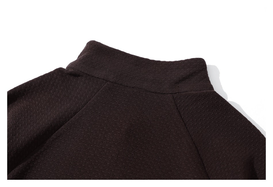 Close-up of the back collar and shoulder seams of a dark burgundy textured jacket.