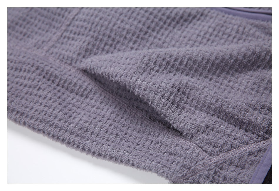 Close-up of the gray garment's textured fabric folded to show its surface and edge.