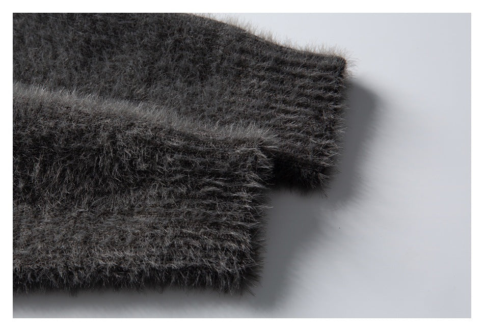 Close-up of a charcoal gray fuzzy knit sleeve ending in a ribbed cuff.