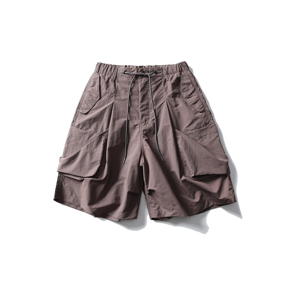 Dusty purple-brown wide-leg shorts with large gathered pockets and a drawcord waist, flat lay