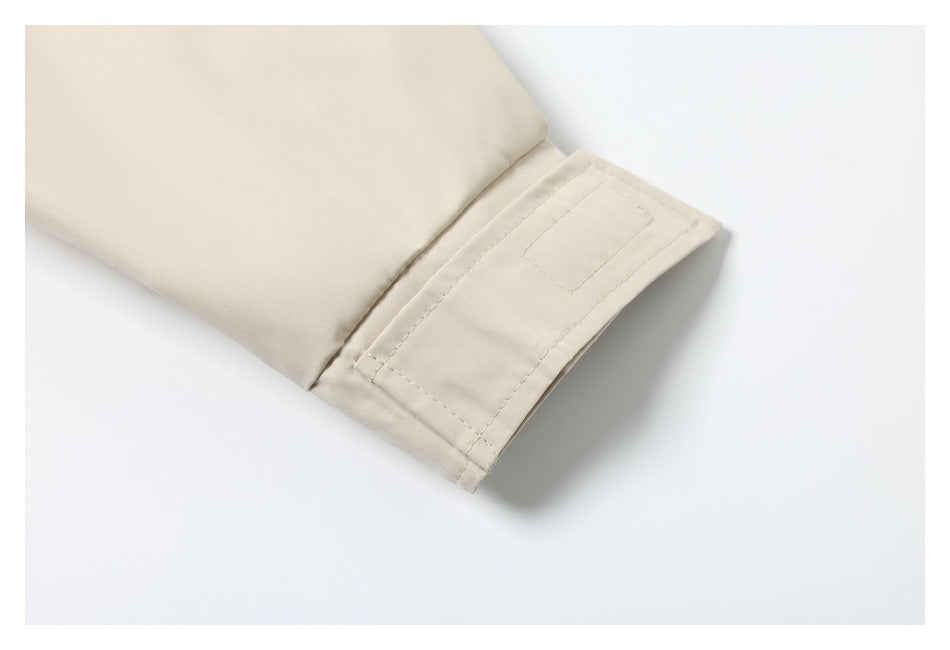 Close-up of the cream jacket sleeve and stitched cuff tab.
