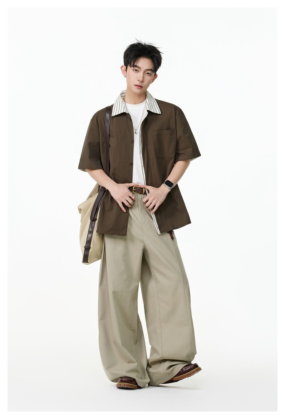 Model wearing a dark brown short-sleeve button-up shirt with a striped collar and light khaki trousers.