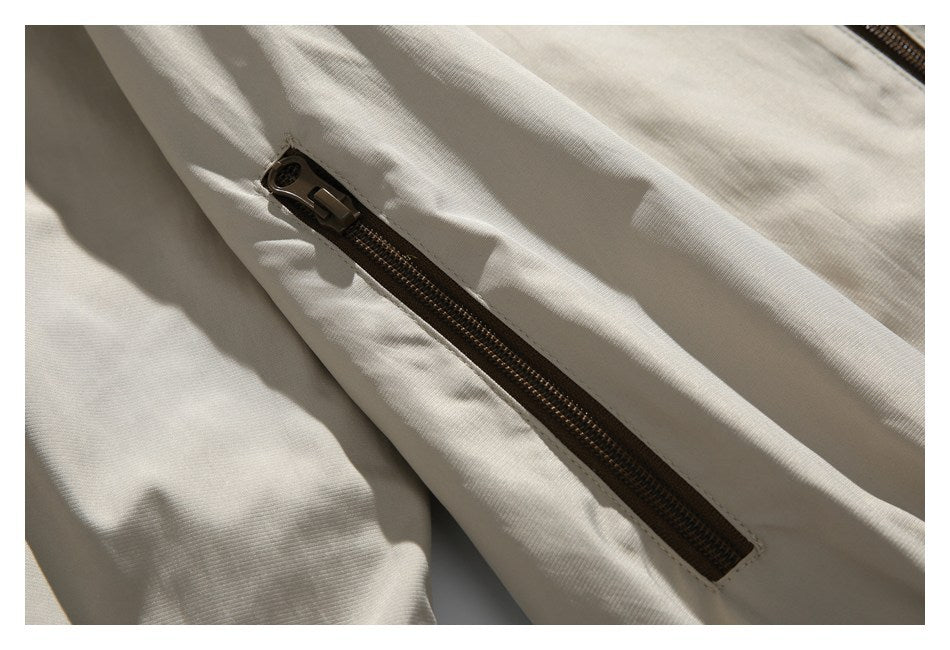 Close-up of a dark brown zip pocket on the beige jacket.