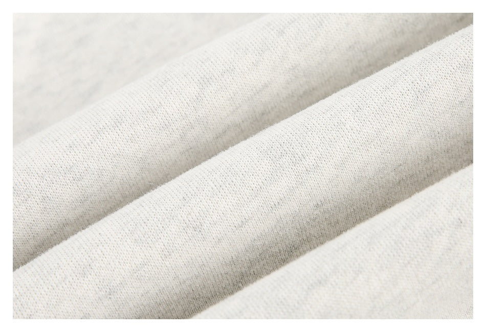 Close-up of off-white knit fabric showing a fine, textured weave.