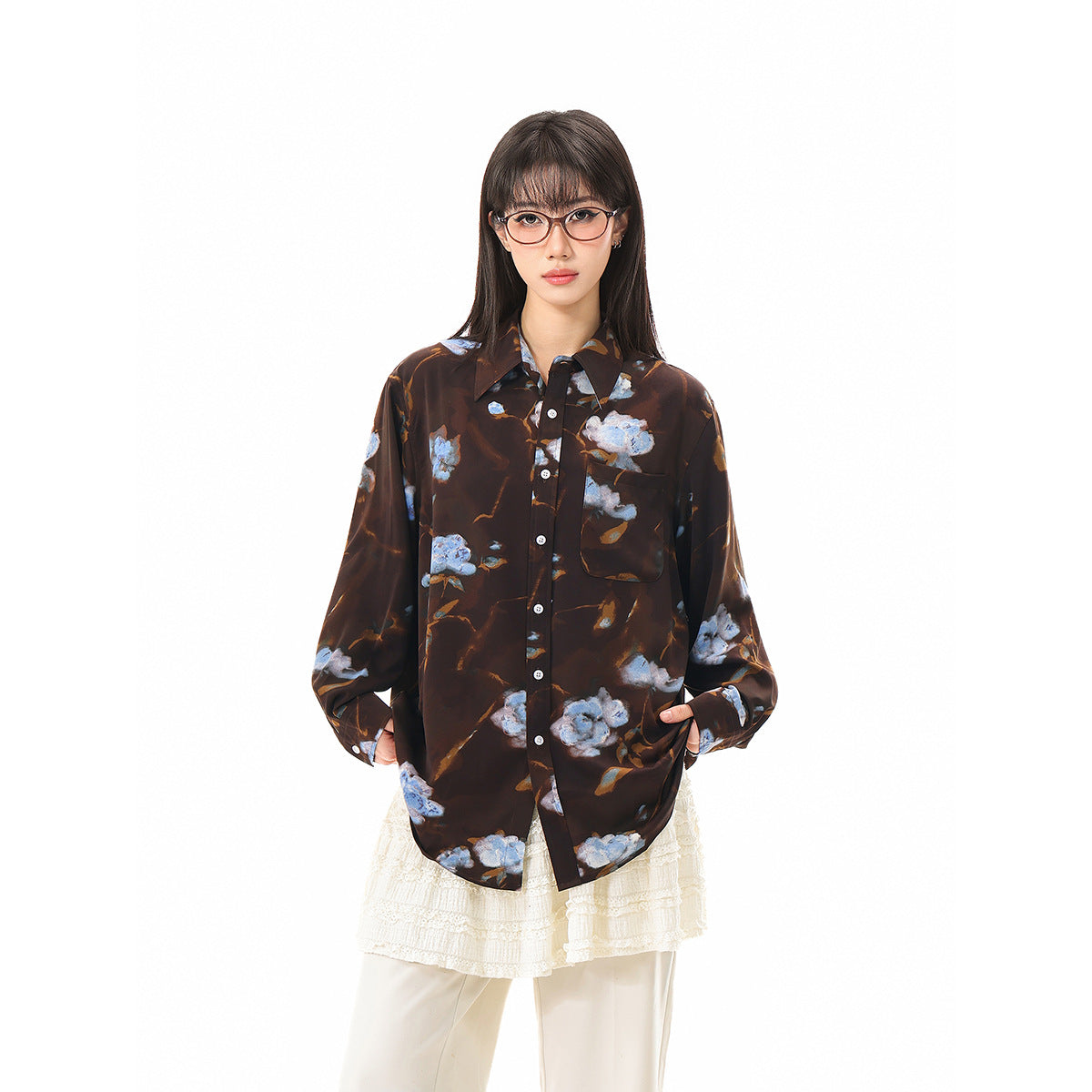 Front view of a model in a dark brown floral button-up shirt with a chest pocket and loose sleeves.