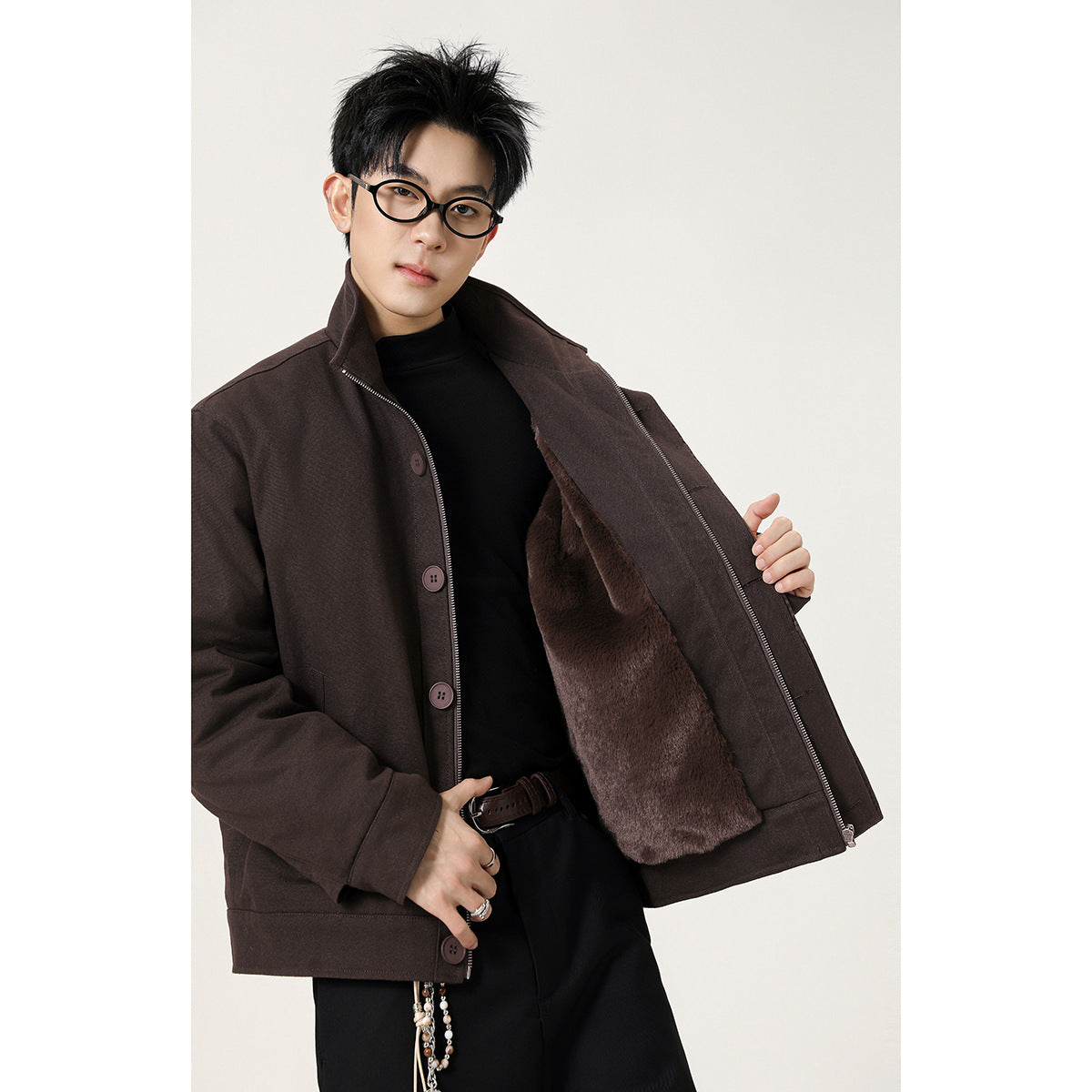 Model opens a dark brown stand-collar jacket to show its plush brown lining, zipper and buttons.