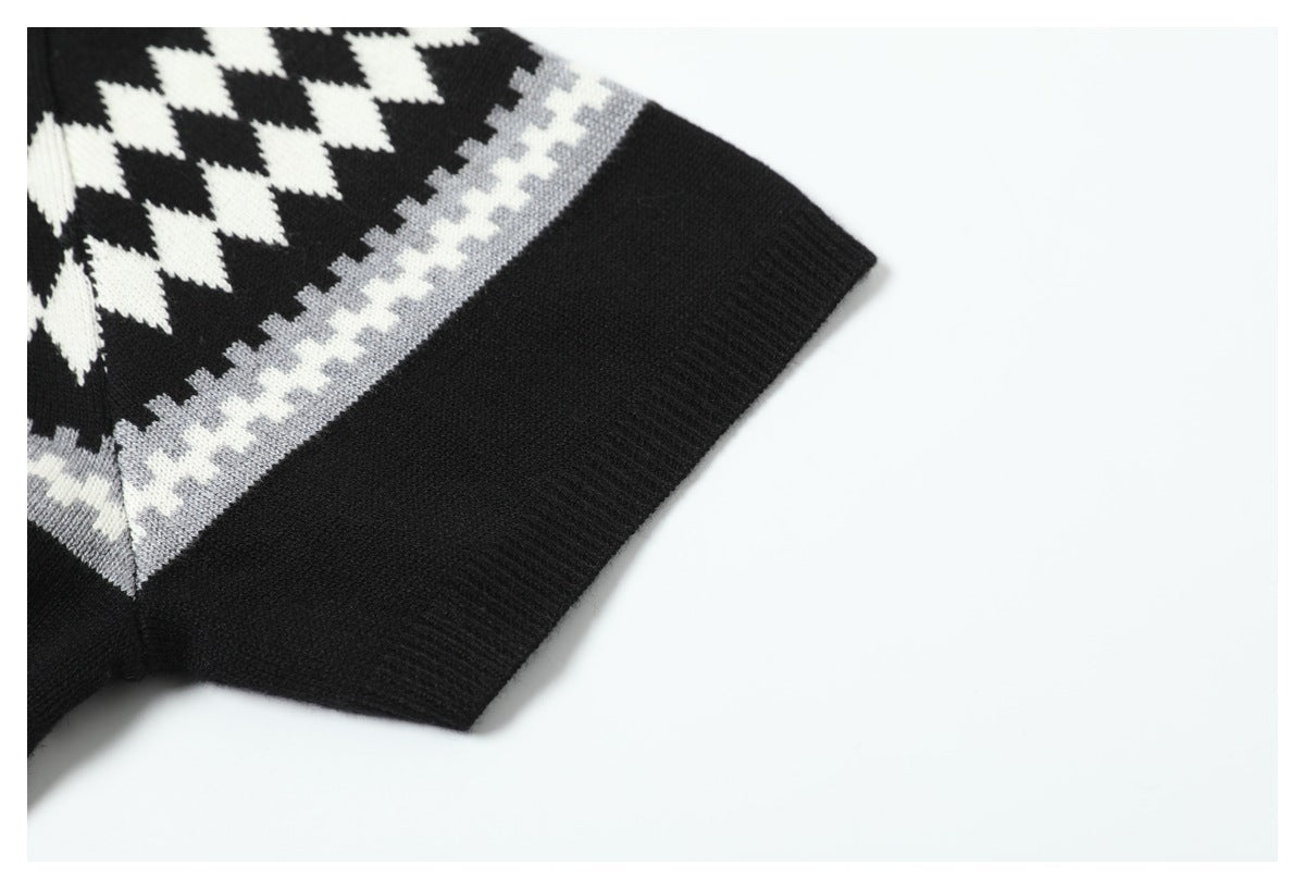 Close-up of a black knit sleeve cuff with white and gray geometric pattern bands.