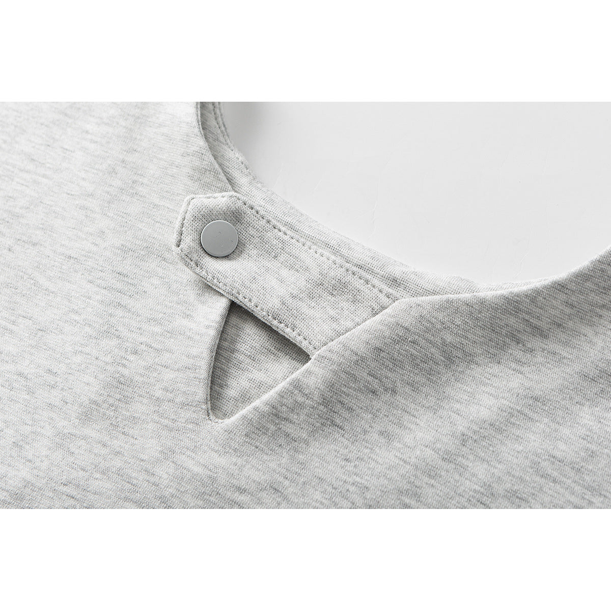 Close-up of a light gray T-shirt neckline with a snap-button closure.