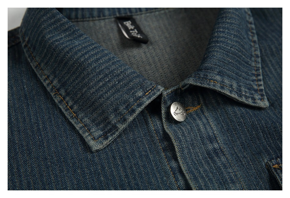 Close-up of the denim jacket's pointed collar, stitching, inner neck label, and a silver button.
