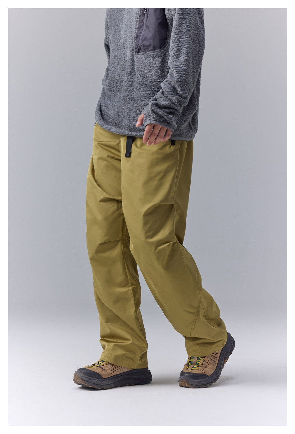 Angled front view of loose olive-yellow pants with a drawstring waist and roomy legs.