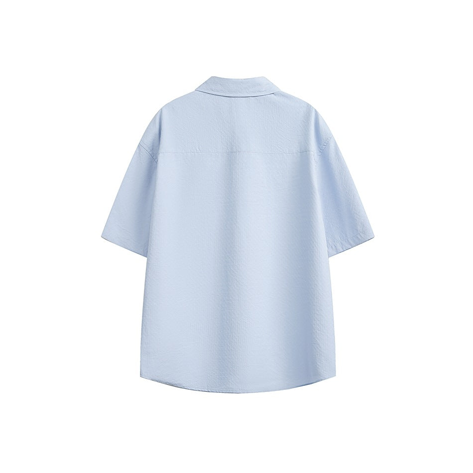 Back view of a light blue short-sleeve button-up shirt with a pointed collar and straight yoke seam.