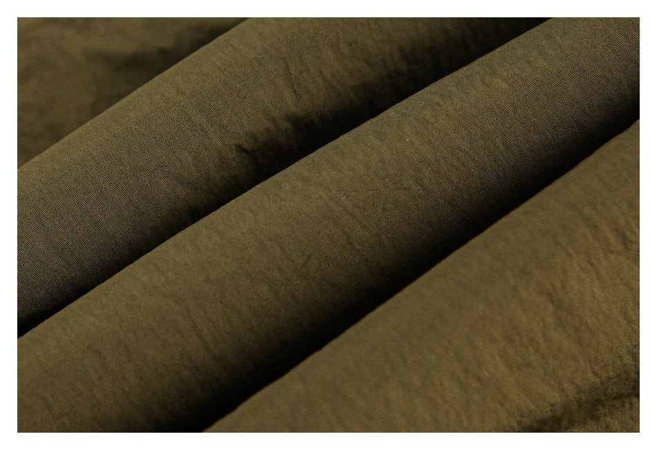 Close-up showing the fine, slightly wrinkled texture of olive garment fabric.