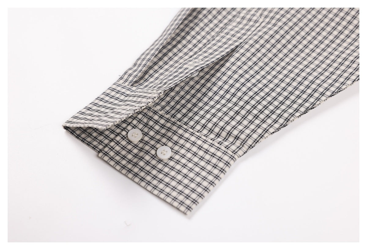 Close-up of a checked shirt cuff with two white buttons and a button placket.