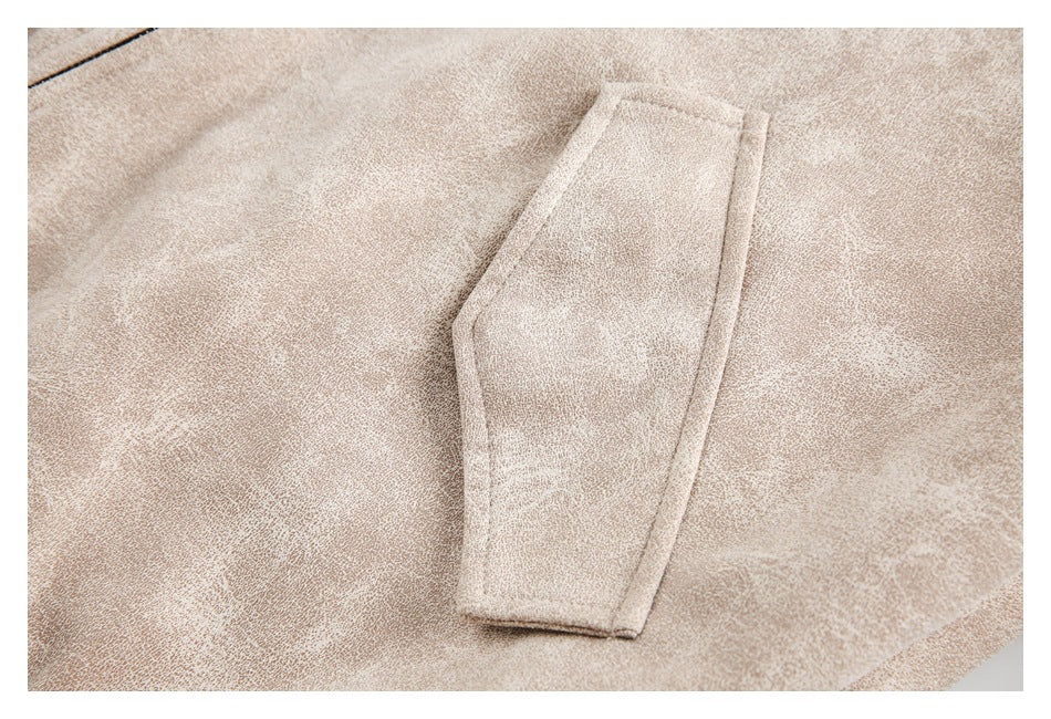Close-up of a narrow stitched pocket on pale beige mottled fabric.