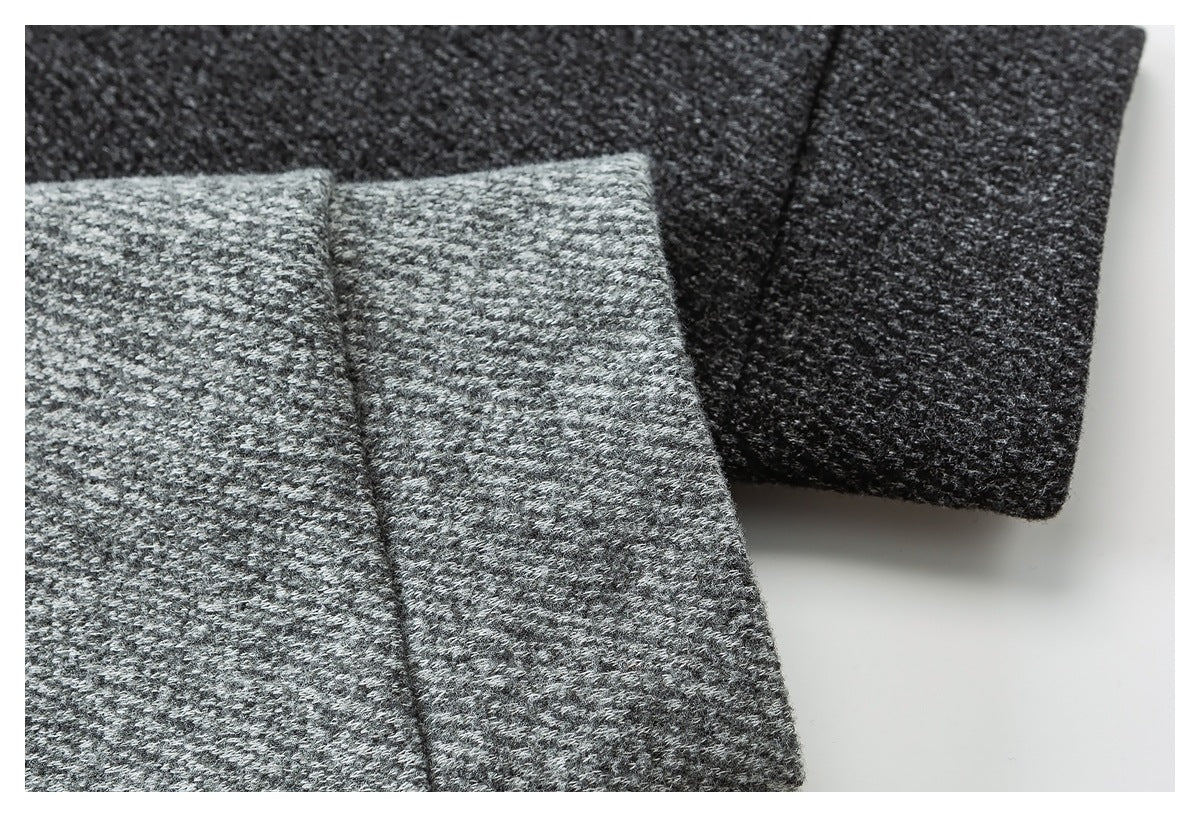 Close-up of light gray and charcoal textured knit sleeves with folded cuffs.