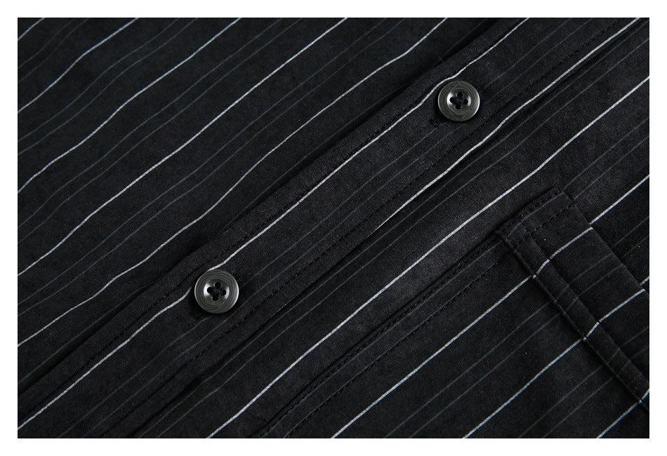 Close-up of two dark buttons and the pale pinstripes on a black shirt.