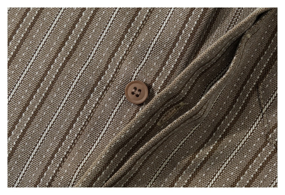 Close-up of a brown button and placket on a shirt with narrow cream stripes.