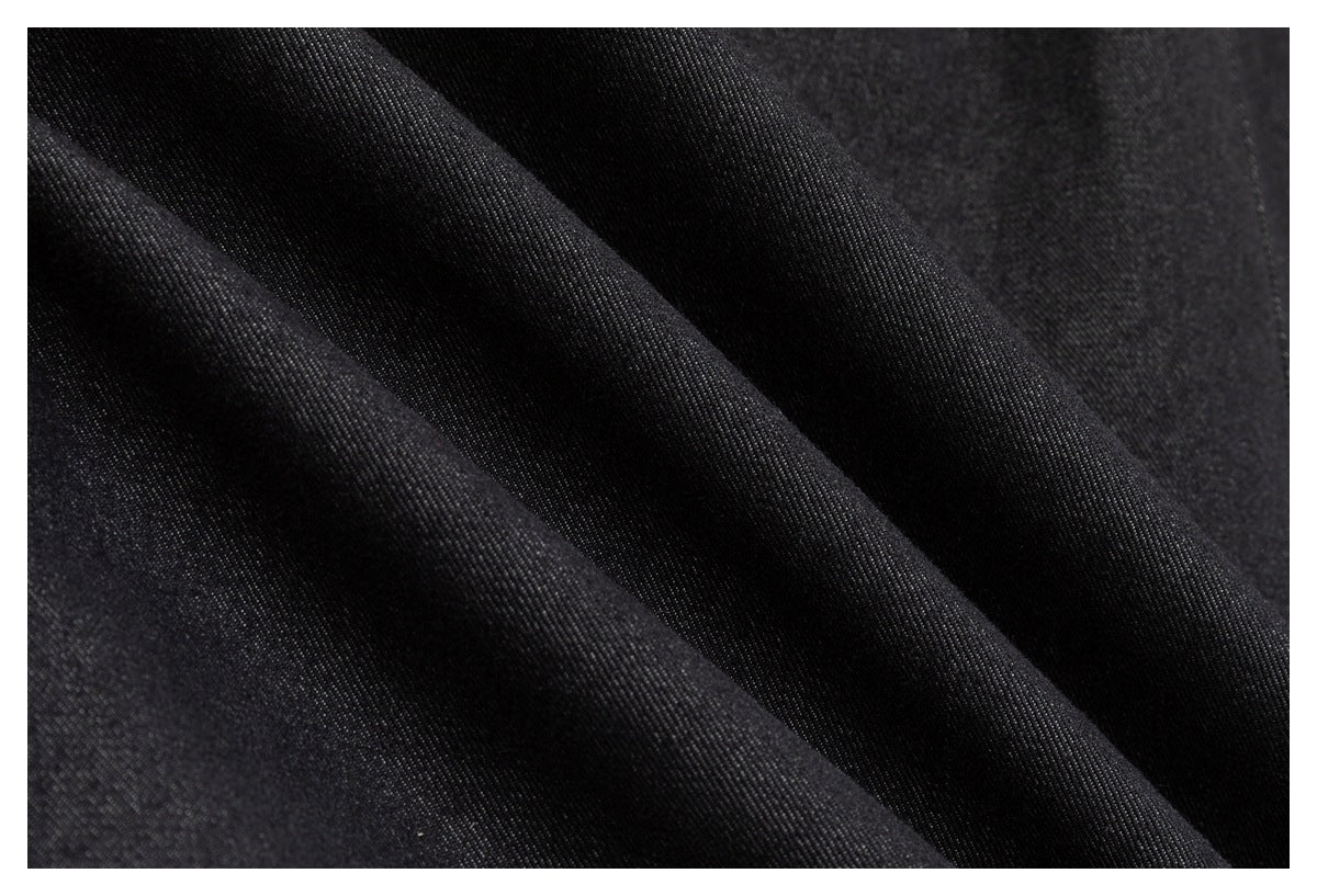 Close-up of black fabric arranged in folds, showing its fine surface texture.