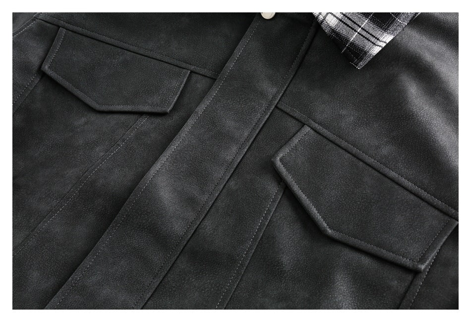 Close-up of a dark jacket front with two flap pockets, a central placket, and a small section of plaid collar.