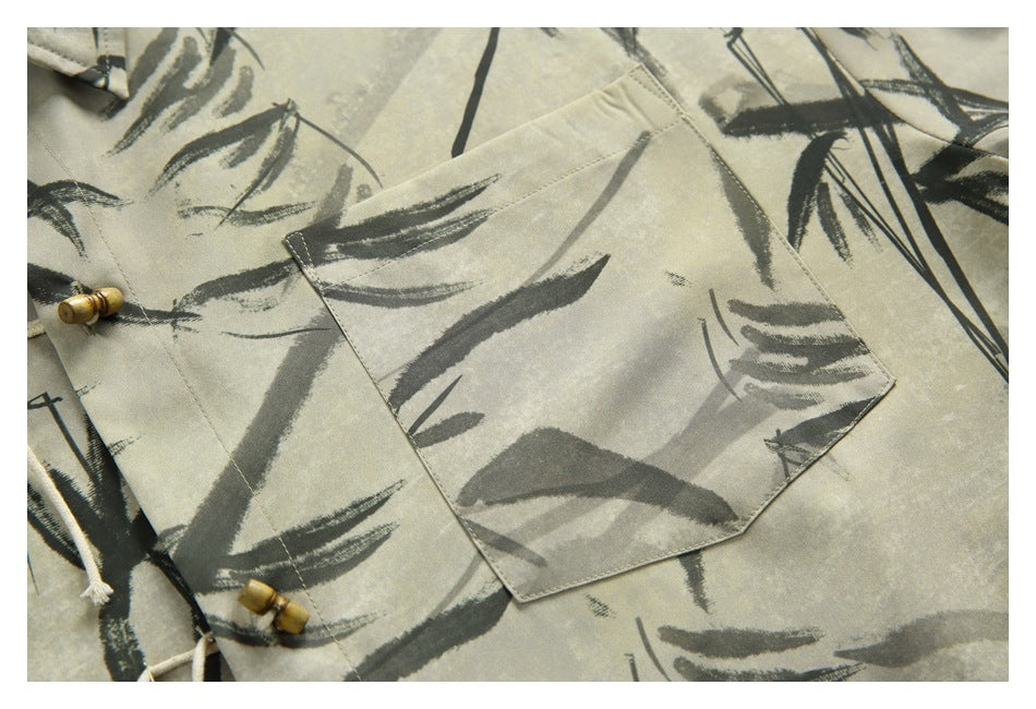 Close-up of a beige shirt pocket with dark bamboo brushstroke print and wooden toggle fasteners.