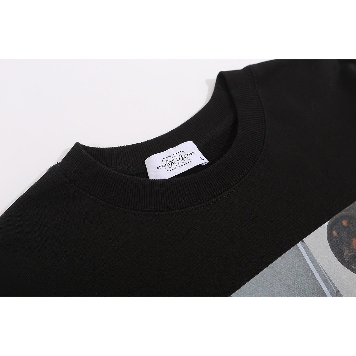 Close-up of a black sweatshirt's ribbed crew neck and white size label.